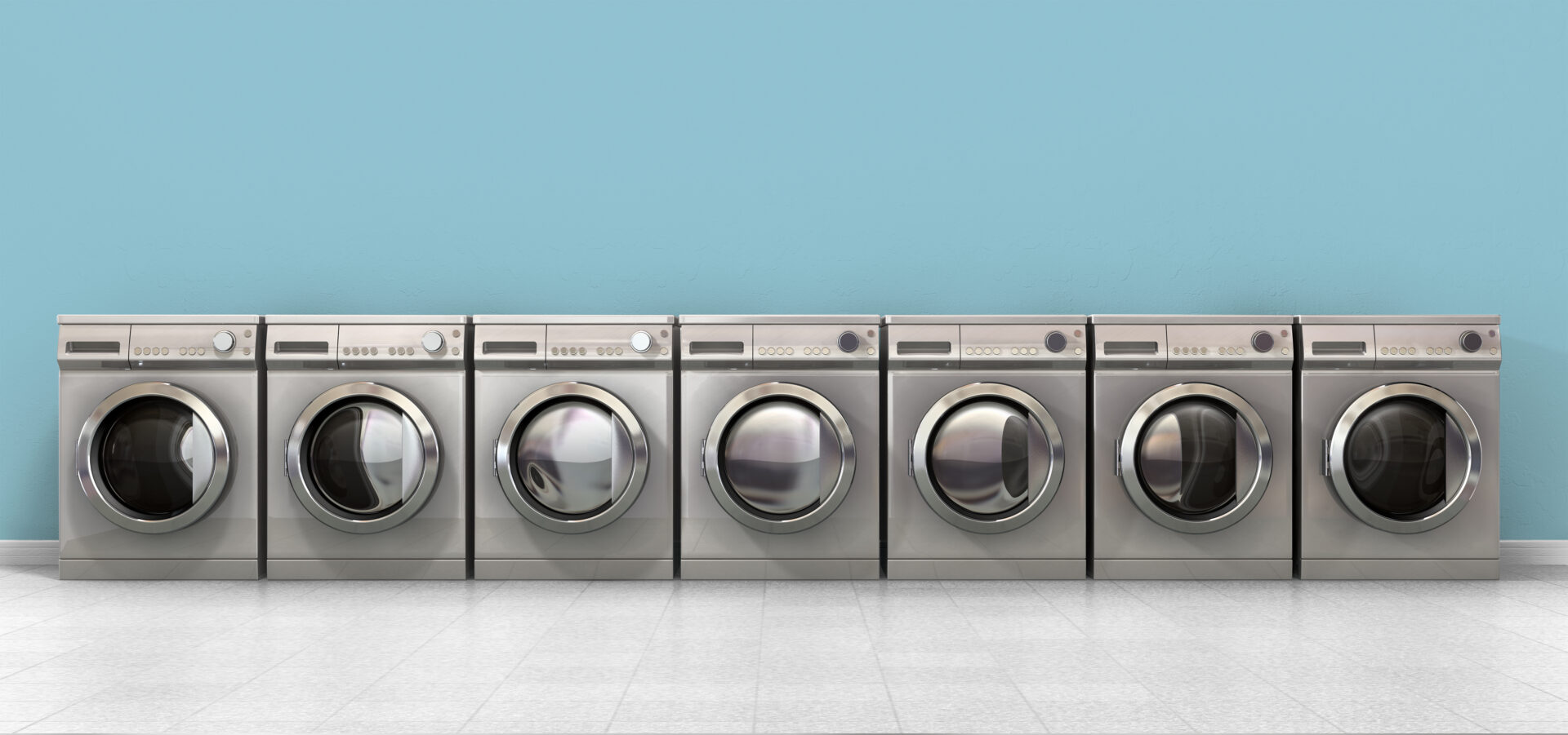 A front view of a row of empty regular brushed metal washing machines in an empty room with a shiny tiled floor and a baby blue wall